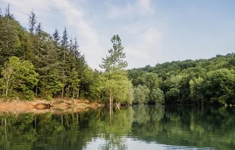 Beautiful Sunset Over Tranquil River Surrounded by Forests and Hills Stock Photos