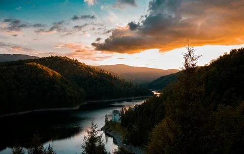 Beautiful Sunset Over Tranquil River Surrounded by Forests and Hills Stock Photos
