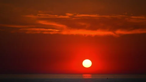 Beautiful sunset over tranquil sea with vibrant red sky and reflections on water Stock Footage 335550534