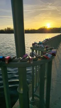 This is a beautiful sunset reflection featuring love locks on a charming bridge Stock Photos