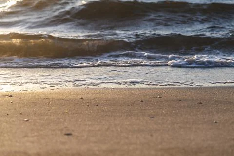 Beautiful sunset reflection on a waves on the beach Stock Photos