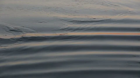 Beautiful sunset reflections on lake surface with thin ice, waves with sun Stock Footage 58650819