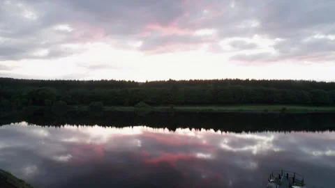 Beautiful sunset reflections over calm lake surrounded by forest Stock Footage 310241055