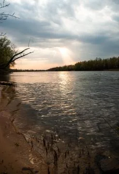 Beautiful sunset river. Bright rays of the sun. Glare on the surface of the Stock Photos