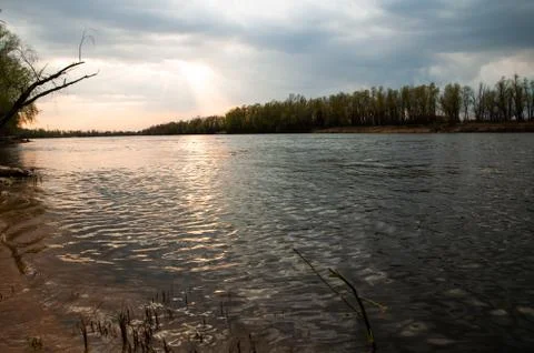 Beautiful sunset river. Glare on the surface of the water. Bright rays of the Stock Photos