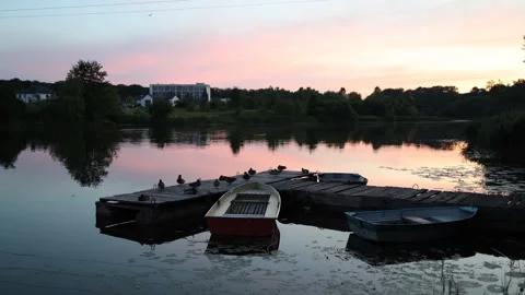 Beautiful sunset on the river, lake. Multi-colored boats sway on the water Stockbeeldmateriaal 291532832