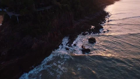 Beautiful sunset scenery with cliffs, ocean, and vibrant sky reflected in water Vídeo Stock 274773224