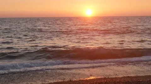Beautiful sunset on the sea coast. Waves at sea, pebble beach. Stock Footage 167352365
