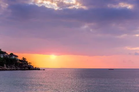 Beautiful sunset at the sea with dramatic clouds and sun shining Stock Photos