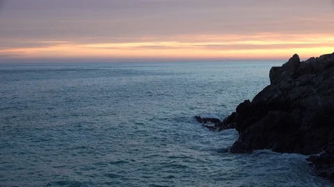 BEAUTIFUL SUNSET ON THE SEA WITH THE WAVES ON THE CLIFFS Stock Footage 100902950