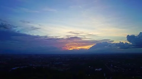 Beautiful sunset sky with clouds over a city landscape Stock Photos