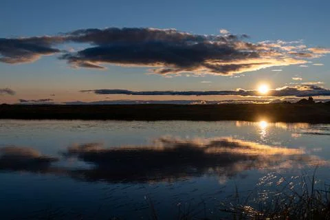 Beautiful sunset sky with dramatic light and clouds and reflection in the lake, Stock Photos