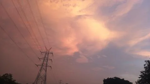Beautiful sunset sky with glowing clouds and electrical transmission 스톡 사진