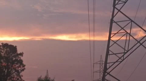 Beautiful sunset sky with glowing clouds and electrical transmission Stock-Fotos