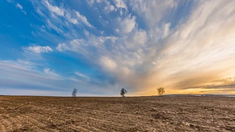 Beautiful sunset sky over plowed field in polish countryside Stock Footage