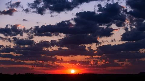 Beautiful sunset sun and clouds over the trees Stock Photos