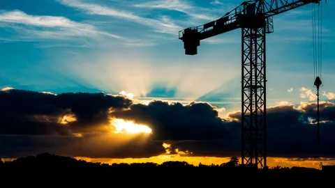 Beautiful Sunset with sun rays over the city with a crane silhouette, timelaps Stock Footage 95858357