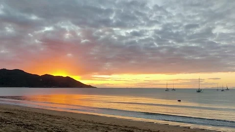 Beautiful sunset with the sun setting behind a hill on a sandy beach. Stock Footage 280057806