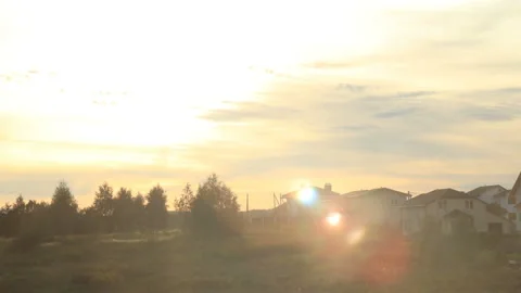 Beautiful sunset with sunbeams and clouds above the village Stock Footage 89690955
