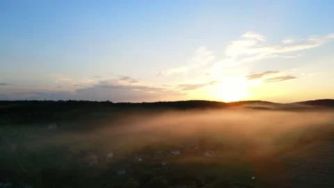 Beautiful sunset, the sun's rays shine through a light fog that falls on the Stock Footage 158544706