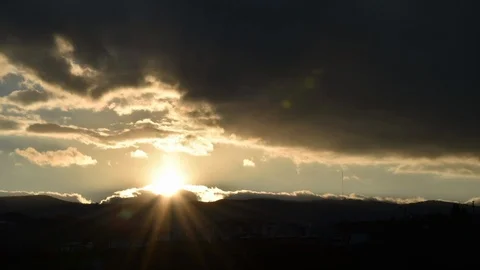 Beautiful sunset timelapse. Sun setting behind mountains. Dramatic clouds. Video stock 104546410