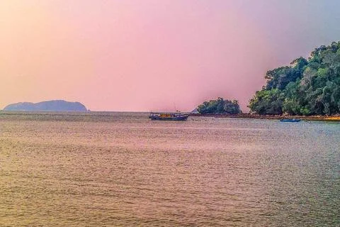 A beautiful sunset view by the beach while watching the boats on the water Stock Photos