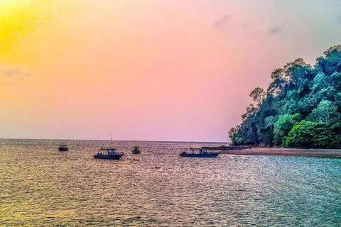 A beautiful sunset view by the beach while watching the boats on the water Stockfoto's