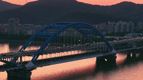 Beautiful sunset view of a bridge over a river with cars passing by and vibrant Stock-Footage 308844489