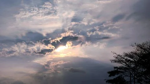 Beautiful sunset view in a cloudy sky in the evening with trees below Fotos de archivo