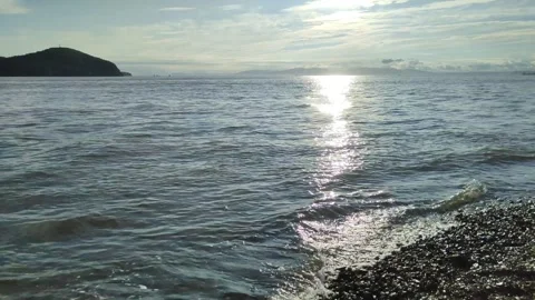 Beautiful sunset view over sea, ocean waves crashing on pebble beach. Seascape Stockbeeldmateriaal 252136021