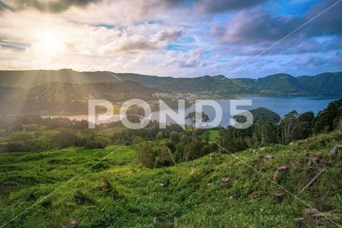 Beautiful sunset volcanic lake among mountains with green lush and trees in C Stock Photos