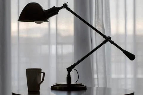 Beautiful table lamp with a cup on the table Stock Photos