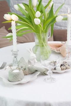 Beautiful table serving for Easter celebration in dining room, candles, glasses Stock Photos