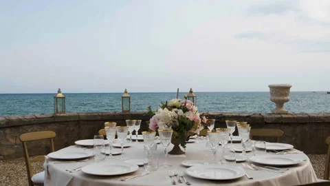 Beautiful table set up for an elegant wedding with candles and flowers by the se Video stock 223964385