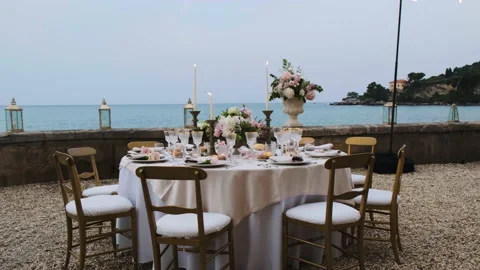 Beautiful table set up for an elegant wedding with candles and flowers by the se Video stock 223964908
