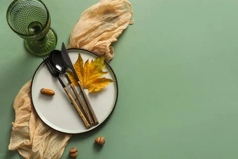 Beautiful table setting with autumn leaf and acorns on green background Stock Photos