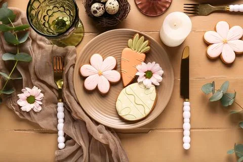 Beautiful table setting with different Easter cookies, eggs, burning candle a Stock Photos