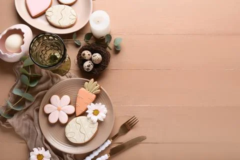 Beautiful table setting with different Easter cookies, eggs, burning candle a Stock Photos
