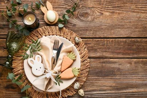 Beautiful table setting with different Easter cookies, eggs, burning candle a Stock Photos