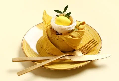 Beautiful table setting with Easter egg and leaves on yellow background Stock Photos