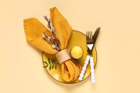 Beautiful table setting with Easter egg and pussy willow branches on yellow b Stock Photos