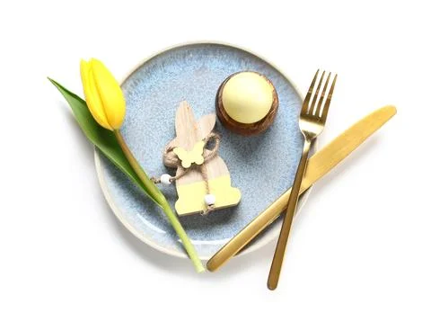 Beautiful table setting with Easter egg, wooden bunny and yellow tulip flower Stock Photos