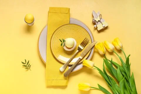 Beautiful table setting with Easter eggs, wooden bunny and tulip flowers on y Stock Photos