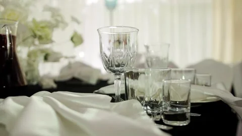 Beautiful table setting with glass goblets, dishes and tablecloth on table in Video stock 304106988