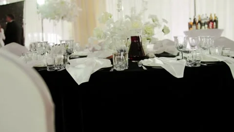 Beautiful table setting with glass goblets, dishes and tablecloth on table in Stock Footage 304107013