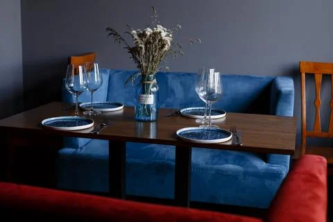 Beautiful table setting with glasses of wine and rose in dark room. Romantic Stock Photos