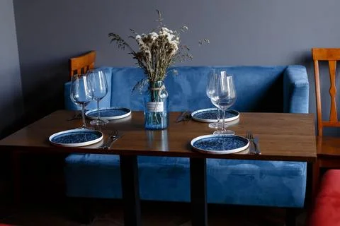 Beautiful table setting with glasses of wine and rose in dark room. Romantic Stock Photos