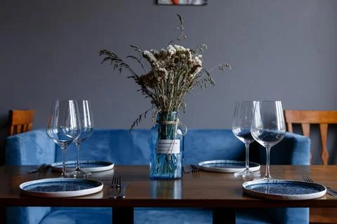 Beautiful table setting with glasses of wine and rose in dark room. Romantic Stock Photos