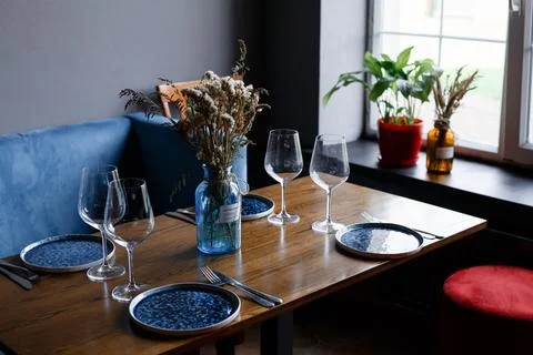 Beautiful table setting with glasses of wine and rose in dark room. Romantic Stock Photos