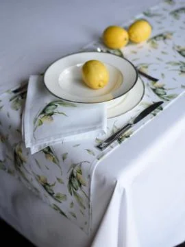 Beautiful table setting - printed tablecloth, plate, yellow lemons Stock Photos